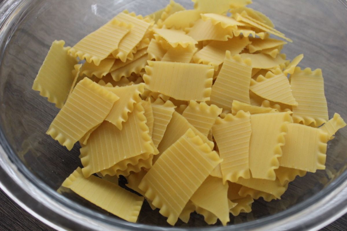 Image of lasagna noodles broken into smaller pieces in a bowl.